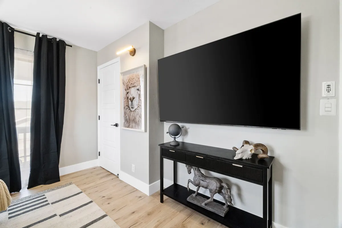 A stylish living area with a large flat-screen TV, unique lion artwork, and a console table with decorative accents. The space is arranged for both relaxation and entertainment, inviting families to gather for movie or game nights after a day exploring downtown.